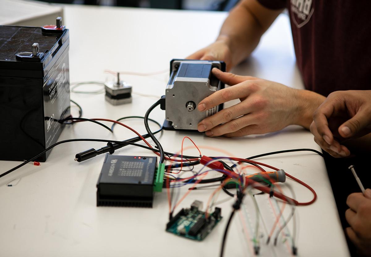 Engineering students connect components with wires